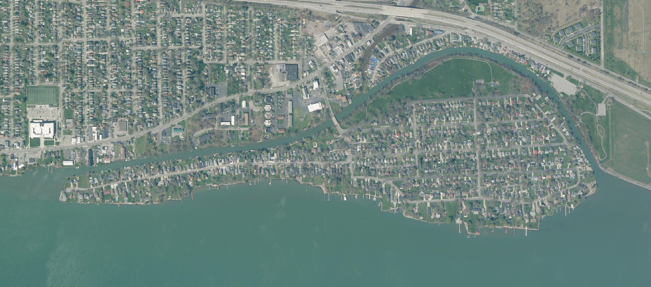 Aerial photograph of Cayuga Island in the upper Niagara River. The Little River channel separates the island from the LaSalle mainland to the north, and the narrow west end points into the river at left.